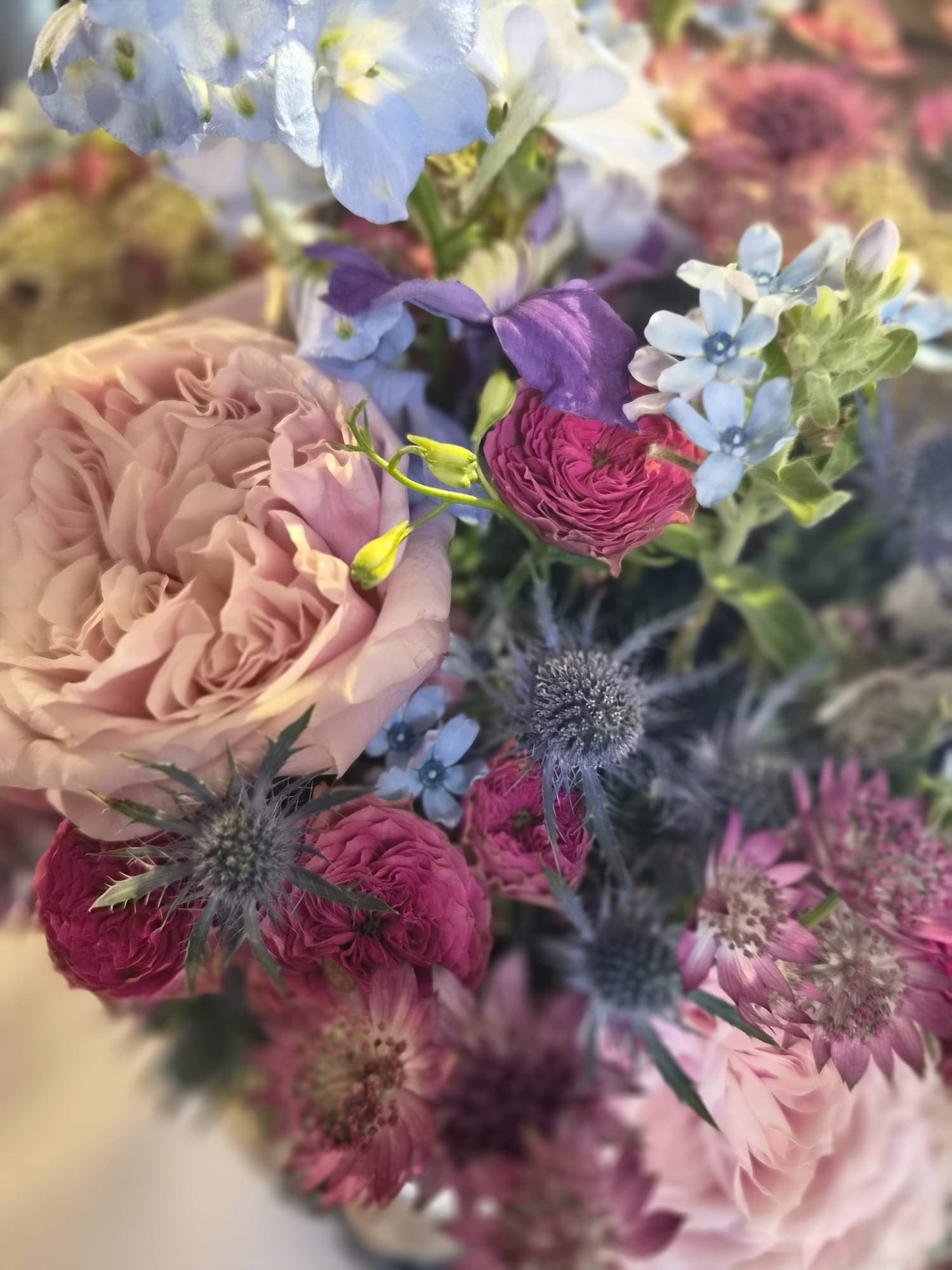 Nahaufnahme eines Blumenstraußes in Rosé, Fuchsia und zartem Blau